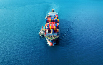 Aerial view of cargo ship with cargo container on sea.